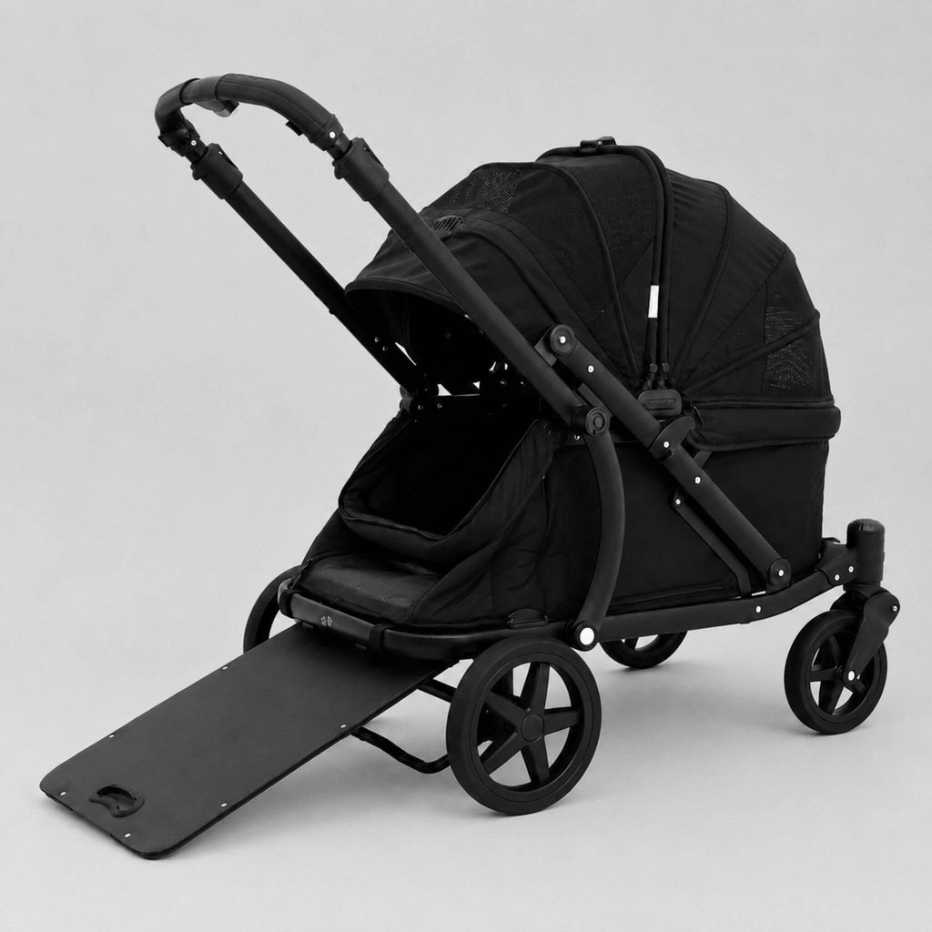 A black pet stroller with a matching black pet bed, black handlebar, and four wheels, shown on a light gray studio background with the front ramp lowered.